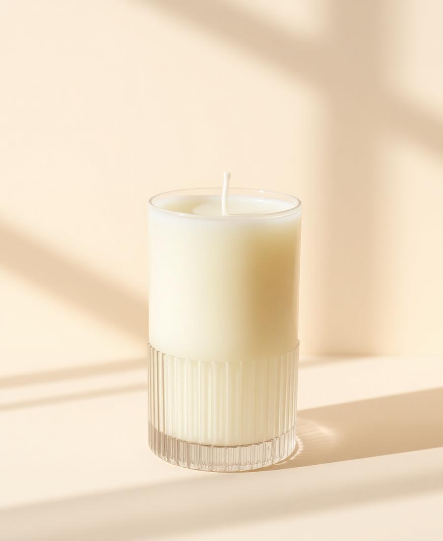 A sculptural unscented Luma candle on a mantle